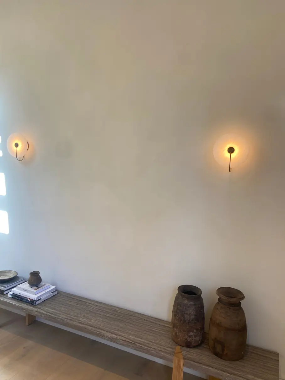 Limewashed living room wall with warm sconces